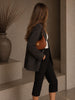 Celine Medium Strap Ava Triomphe Tan Calfskin — lifestyle photo: worn on the shoulder with a dark blazer, gold Triomphe hardware visible on the front.