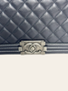 Chanel Boy Medium Black Lambskin — detail: close-up of the CC turn-lock closure on the quilted flap.