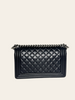 Chanel Boy Medium Black Lambskin — back view showing the plain quilted back panel and full chain strap.