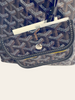 Goyard Bohème Mini Hobo Navy Goyardine — detail: close-up of the front pouch flap in navy Goyardine chevron canvas with dark brown leather trim and a silver snap button. 
