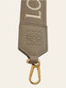 Loewe Anagram Strap in Jacquard and Calfskin Sand Gold — detail: close-up of the embossed Anagram leather tab and gold clasp.
