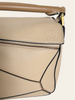 Loewe Small Puzzle Sand Calfskin — detail: close-up of the embossed LOEWE logo on the geometric front panel.