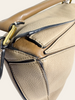 Loewe Small Puzzle Sand Calfskin — detail: close-up of the top handle attachment hardware and geometric panel seams.