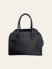 The Row Soft Margaux 10 Black Grained Calfskin. Back view of the black grained calfskin bag with the adjustable shoulder strap visible resting behind it.