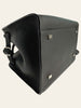 The Row Soft Margaux 10 Black Grained Calfskin — detail: angled base/side view of the black grained calfskin bag showing the metal feet studs and strap buckle up close.