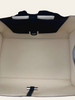 The Row Soft Margaux 10 Black Grained Calfskin — interior view: overhead interior view showing the beige/cream lining, a black leather panel, and D-ring hardware inside the bag.